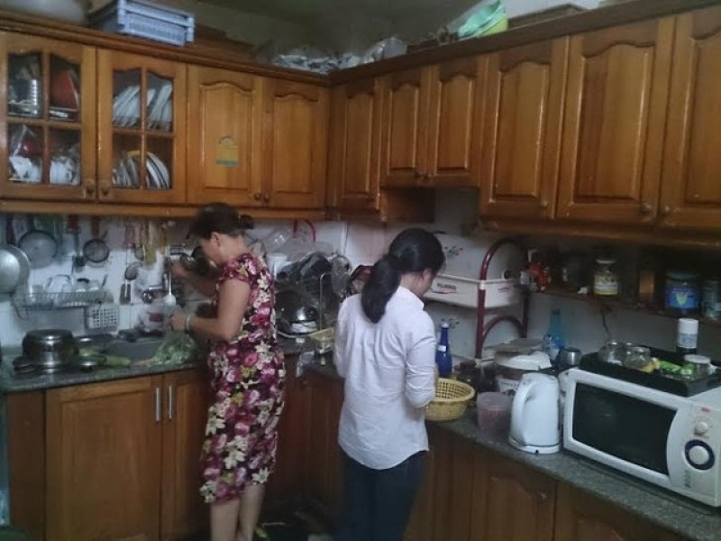 Hai phụ nữ đang rửa và sắp xếp đồ dùng trong bếp
