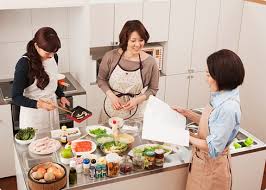 Người phụ nữ đeo găng tay đang lau bề mặt trong căn bếp