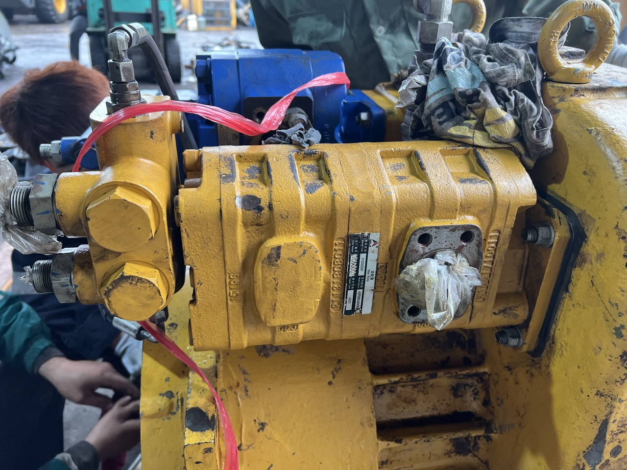 Cụm bơm số (bơm truyền động) màu vàng được lắp trực tiếp trên thân hộp số máy xúc lật SDLG L956F