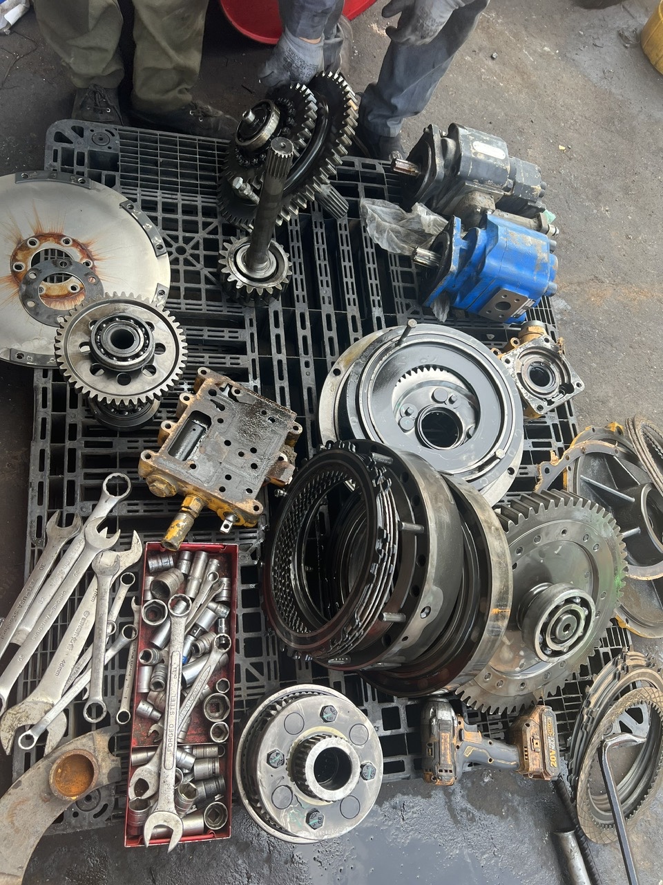 Kiểm tra phân loại các phụ tùng hộp số xúc lật bao gồm lá côn ma sát, bánh răng và tháp van trước khi ráp