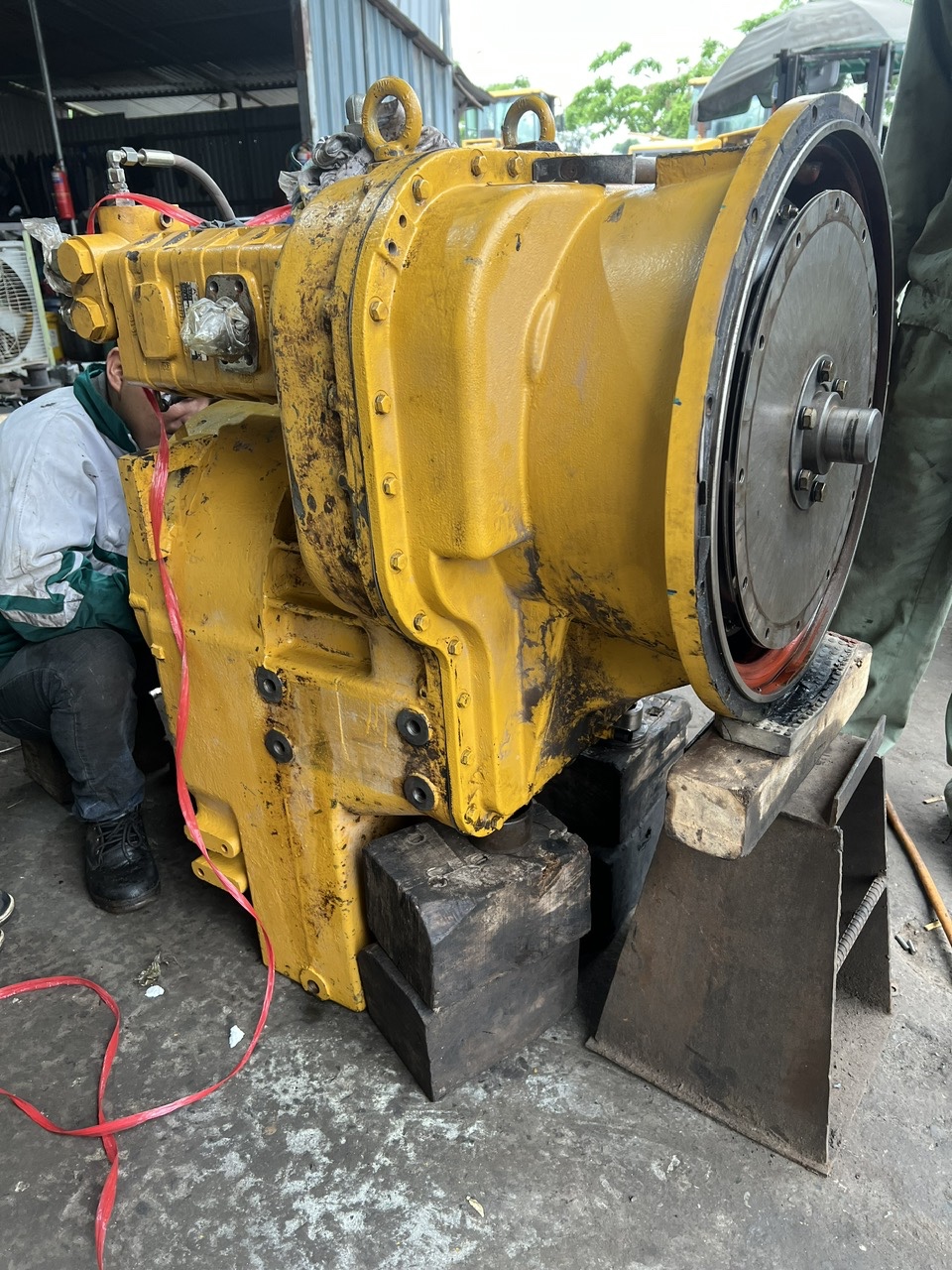 Tổng thể cụm hộp số và biến mô máy xúc lật SDLG L956F đang được hạ xuống bục kỹ thuật để thay bơm