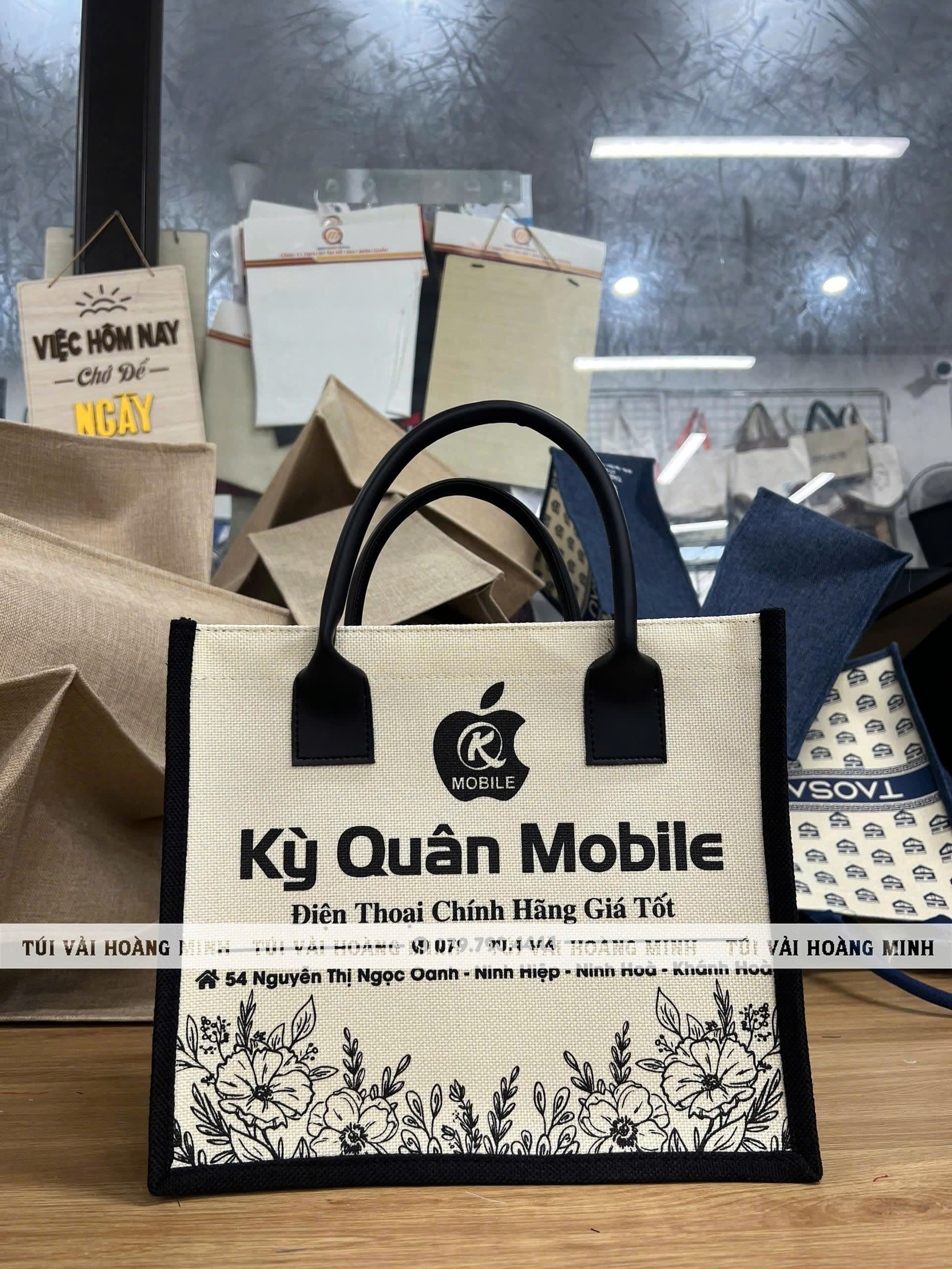 Túi vải linen in logo Kỳ Quân Mobile màu kem viền đen quai xách sang trọng, thiết kế dành riêng cho cửa hàng điện thoại chính hãng tại Khánh Hòa.
