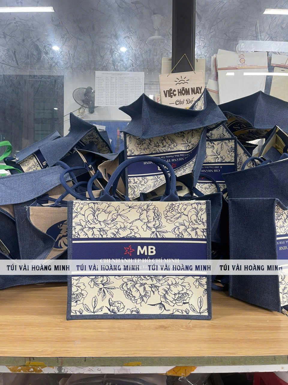  túi vải linen in logo ngân hàng MB nổi bật màu xanh đậm với họa tiết hoa văn màu kem 
