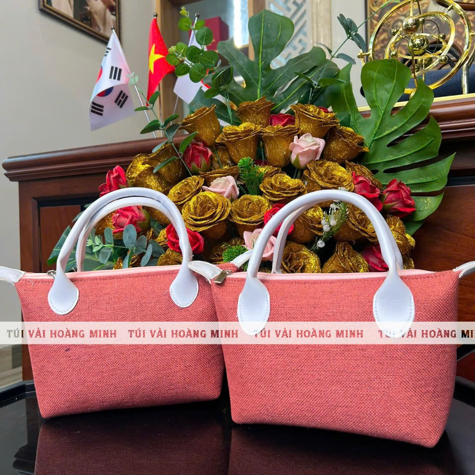 Túi luxury màu hồng quai da trắng với chất liệu vải linen cán xốp