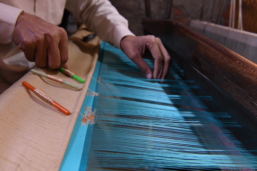 Muốn tạo nên những miếng vải gấm nhiều kiểu dáng, người thợ phải dệt nổi từ chiếc khung cửi thiết kế hai tầng, hay còn lại là khung hoa