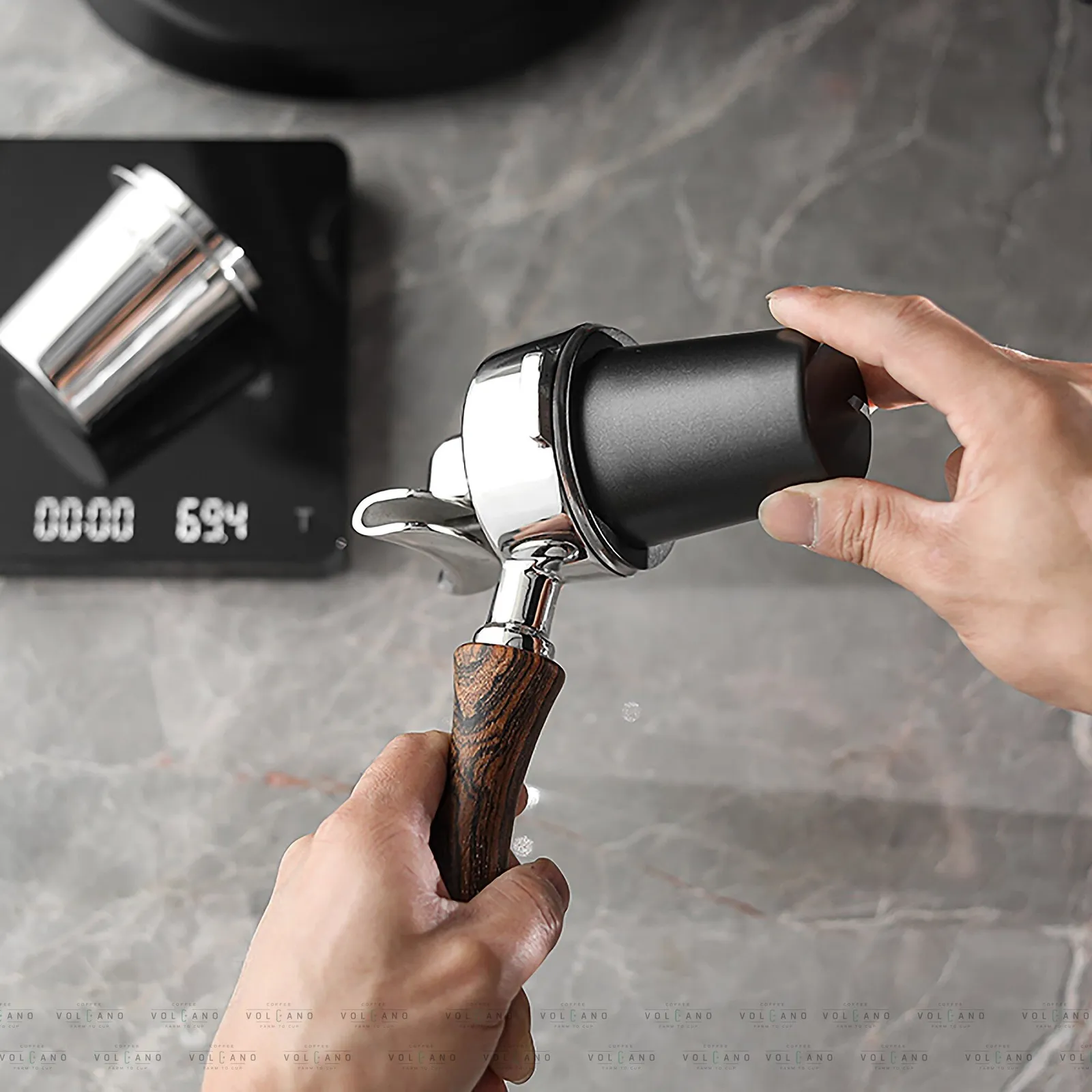 Cân điện tử hiển thị khối lượng bột trong ly dosing cup inox trước khi trút vào tay pha