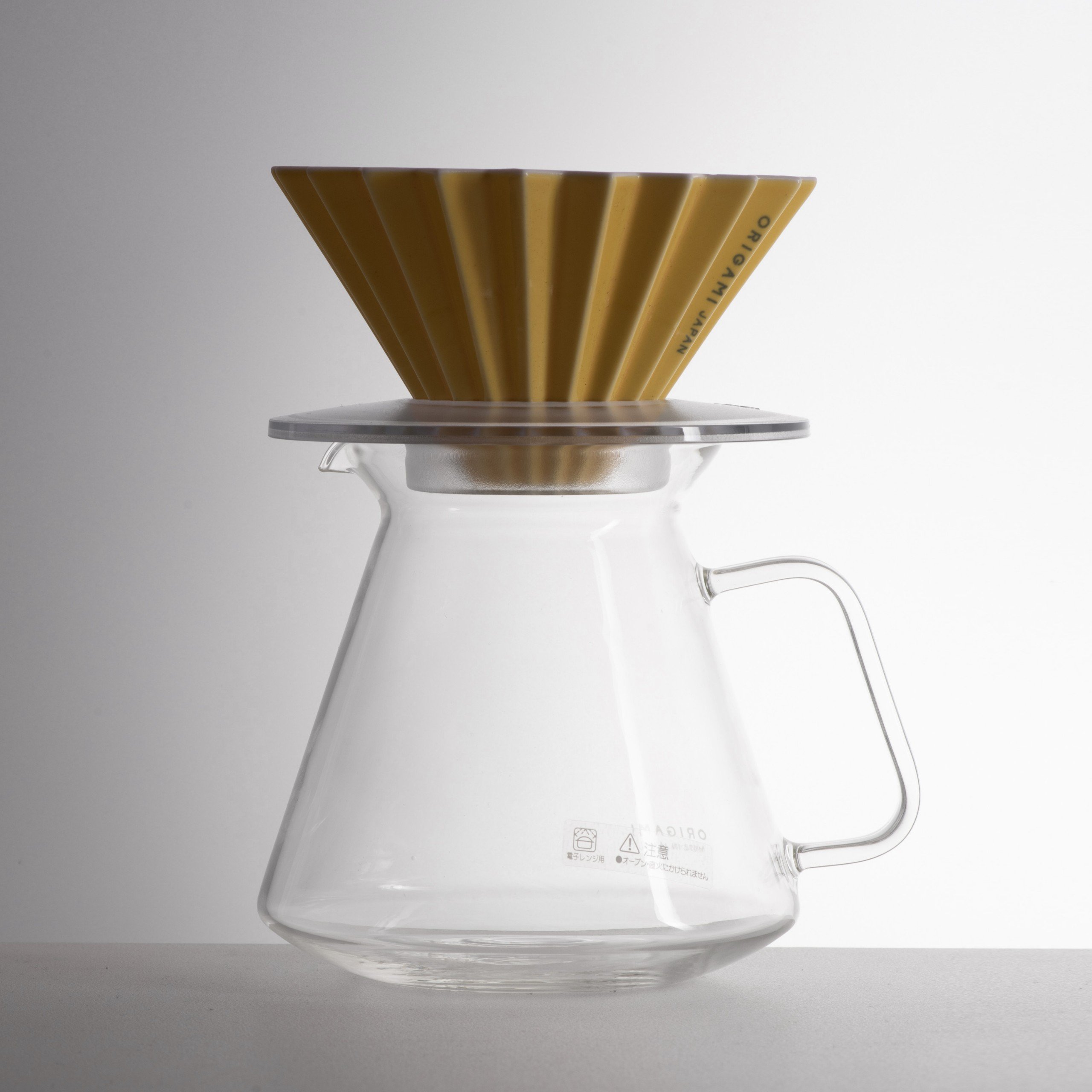 Combo V60 Origami Dripper M: phễu sứ màu vàng đồng đặt trên giá đỡ và bình thuỷ tinh Origami x Hario 710ml