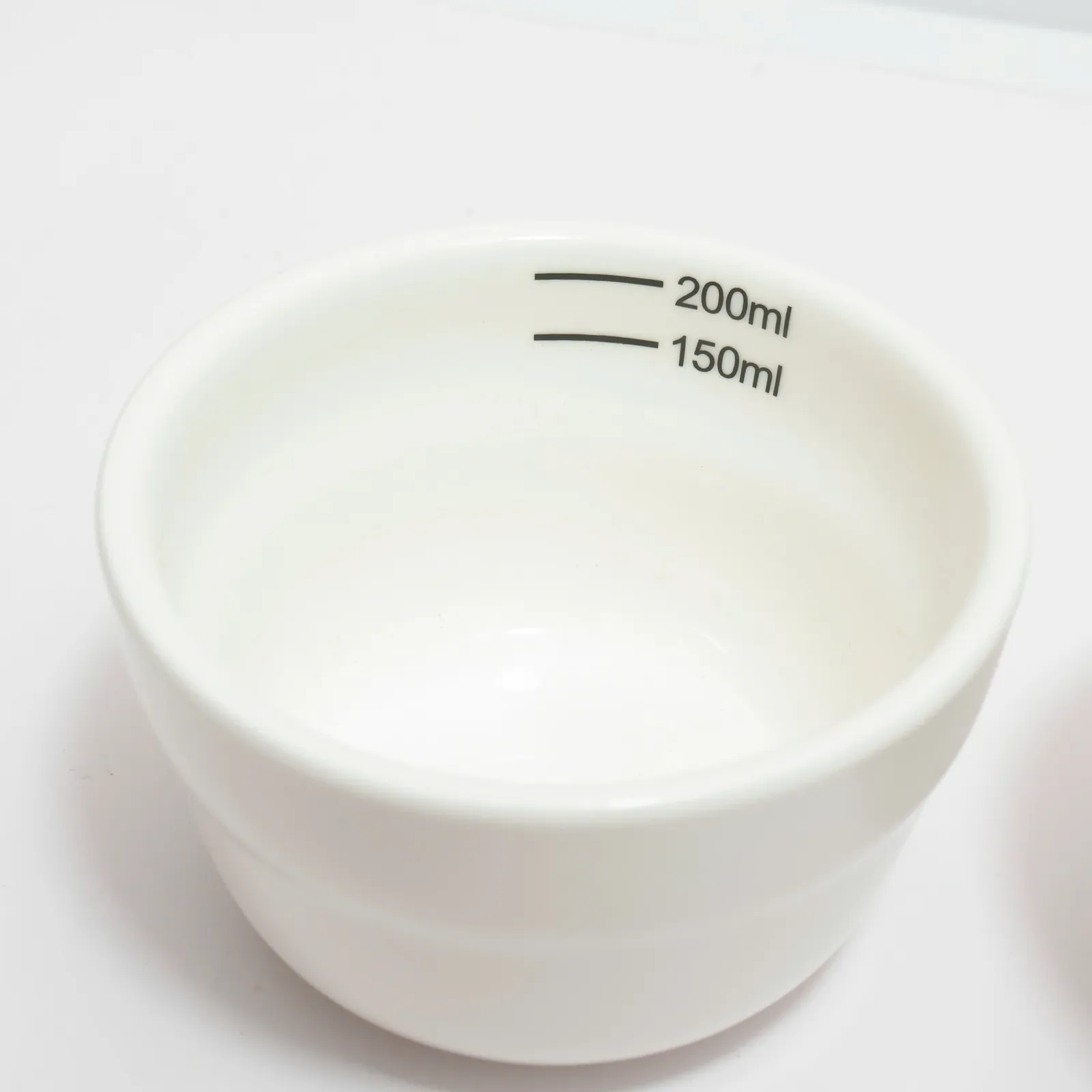 Rót nước nóng vào chén cupping đựng bột cà phê đặt trên đế gỗ tròn