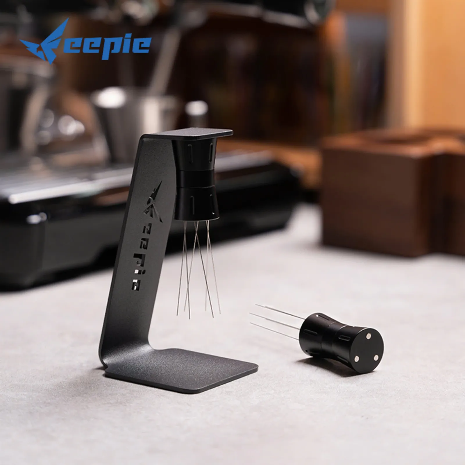 Kim tán bột Feepie tháo rời khỏi giá đỡ, đặt cạnh máy pha espresso