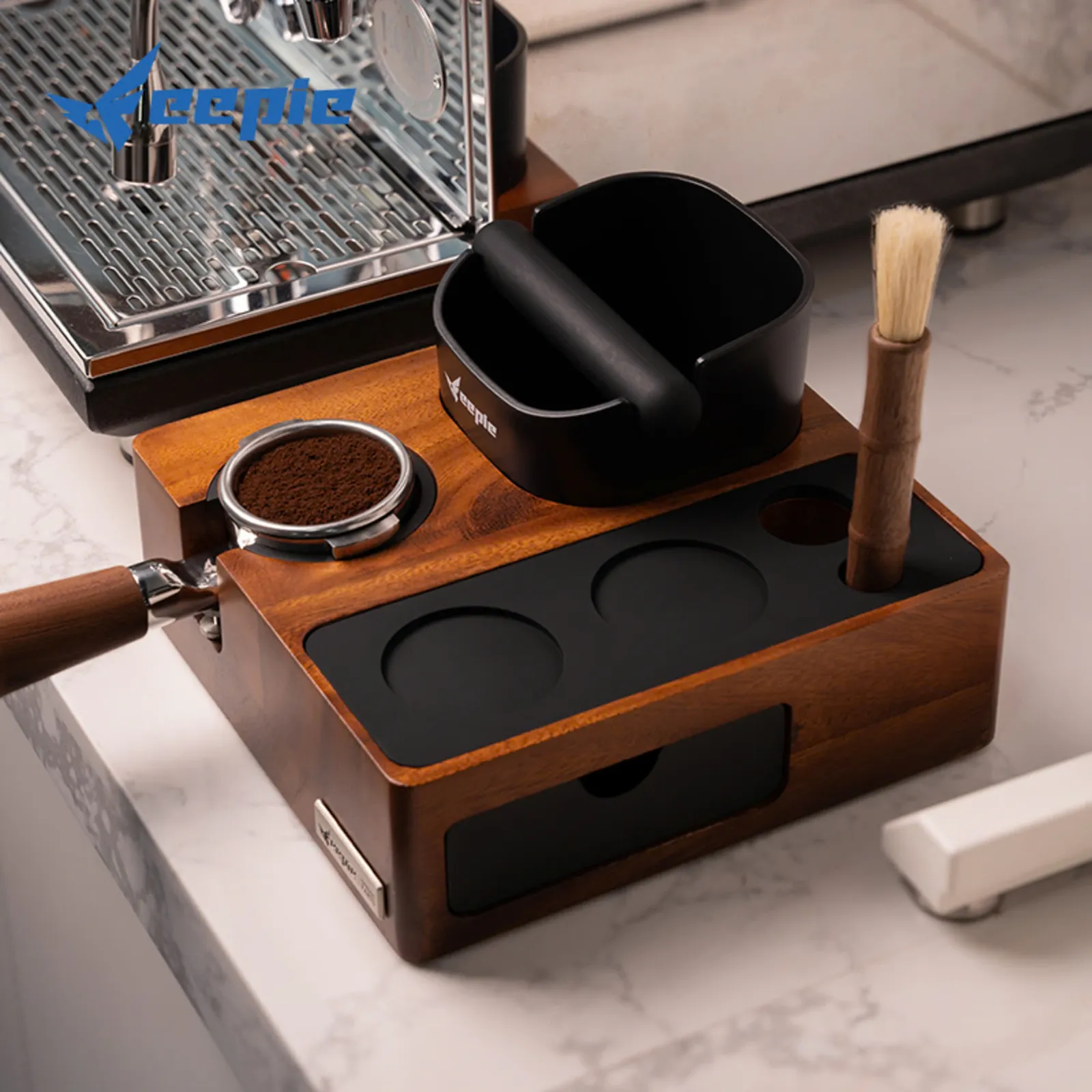 Bàn đế nén Feepie trên mặt bàn đá cẩm thạch cùng tay cầm portafilter đầy bột và cọ vệ sinh