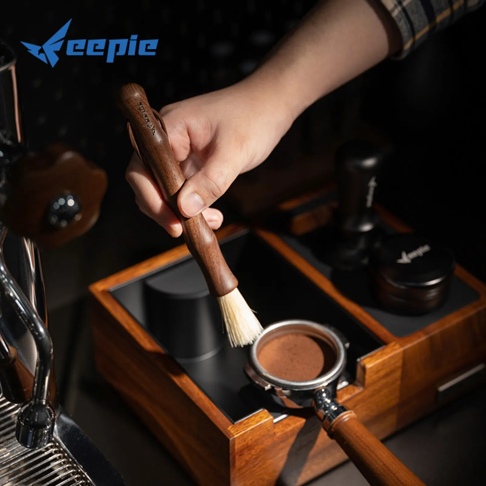 Cọ quét cà phê Feepie cán gỗ óc chó trên tay barista trong quầy bar