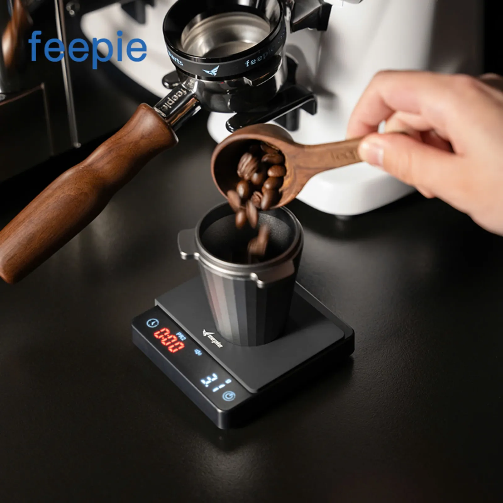 Đong hạt cà phê bằng muỗng gỗ vào tay cầm portafilter đặt trên cân điện tử Feepie