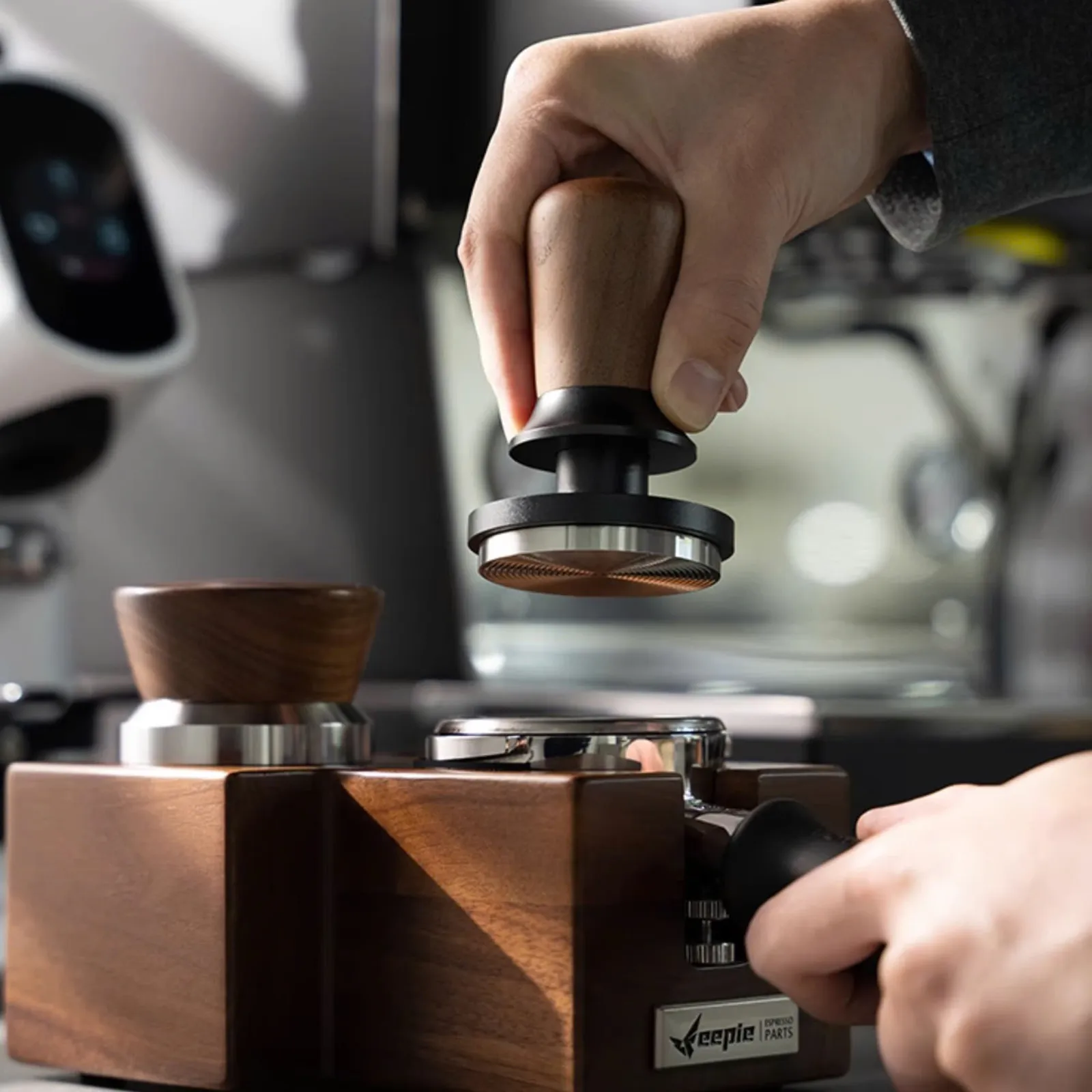 Barista dùng Tamper Feepie Wood Charm nén bột cà phê trong quầy bar espresso
