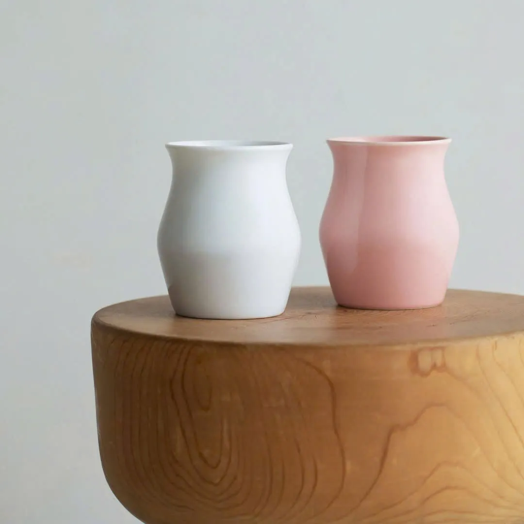 Hai ly Origami Sensory Flavor Cup màu trắng và hồng trên mặt gỗ
