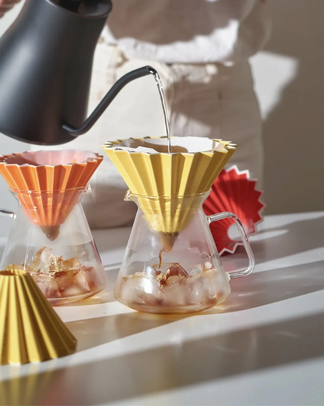 Nhiều phễu sứ Origami Dripper S các màu đang pour over trên bình thuỷ tinh