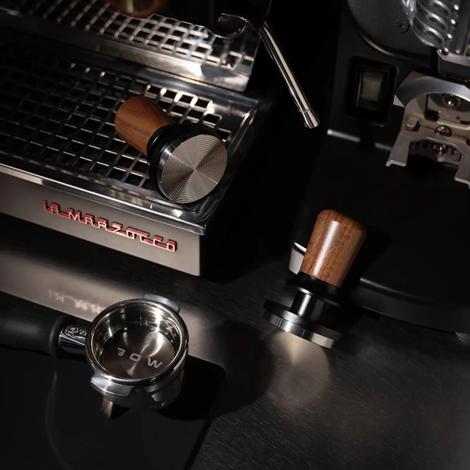 Tamper Feepie Wood Charm trên quầy bar cạnh máy pha La Marzocco