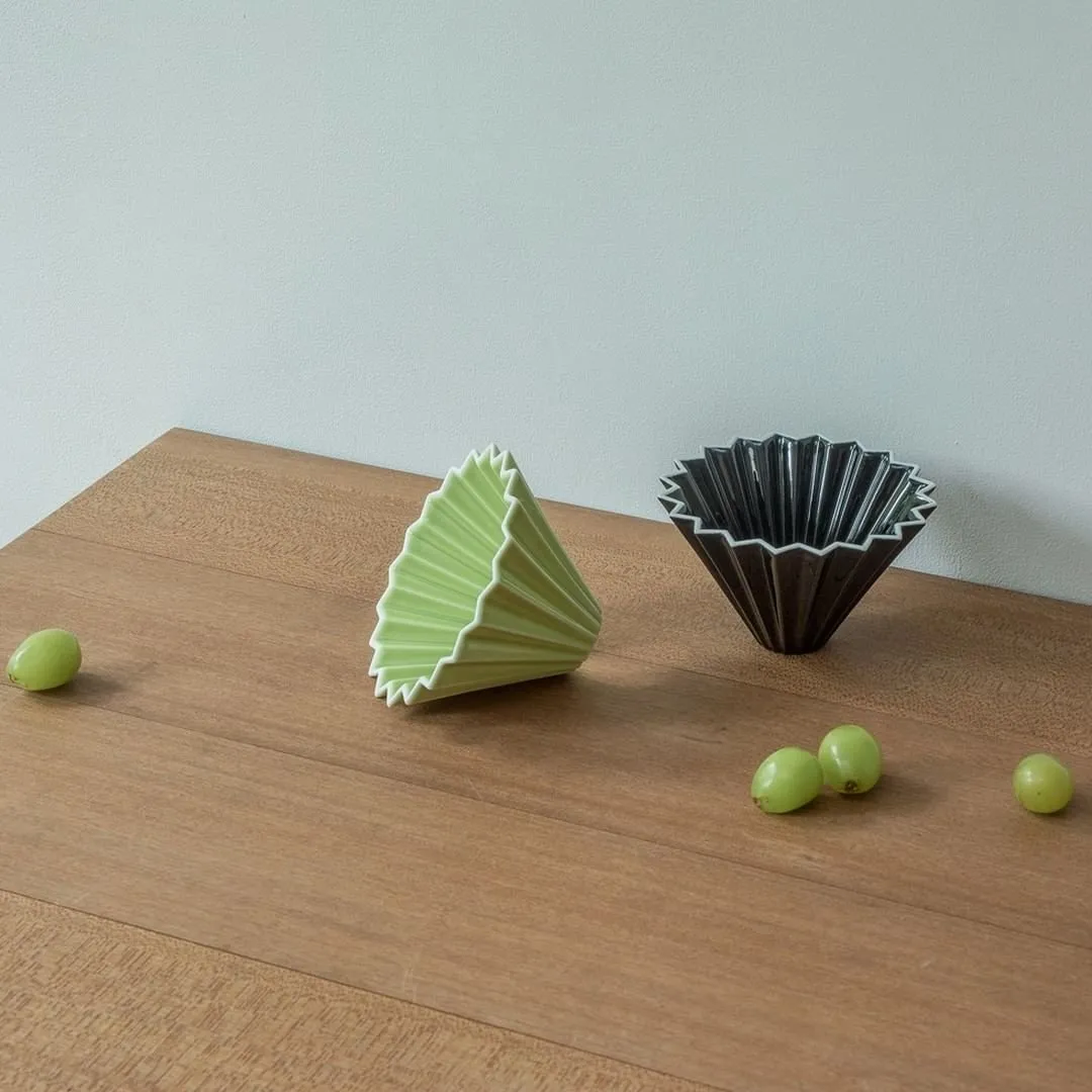 Phễu sứ Origami Dripper S màu Matte Green và Matte Black trên bàn gỗ
