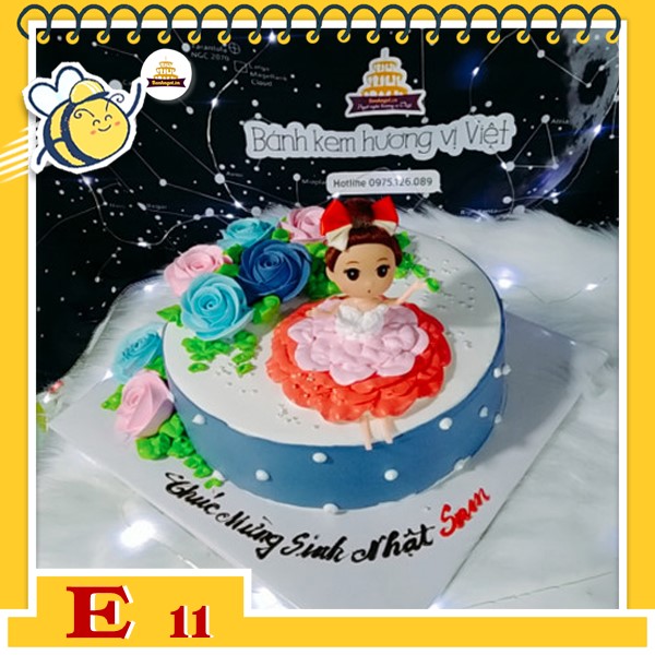 Bánh kem búp bê E11 thân màu xanh chấm bi trắng bắt hoa nhiều màu xanh hồng váy đỏ