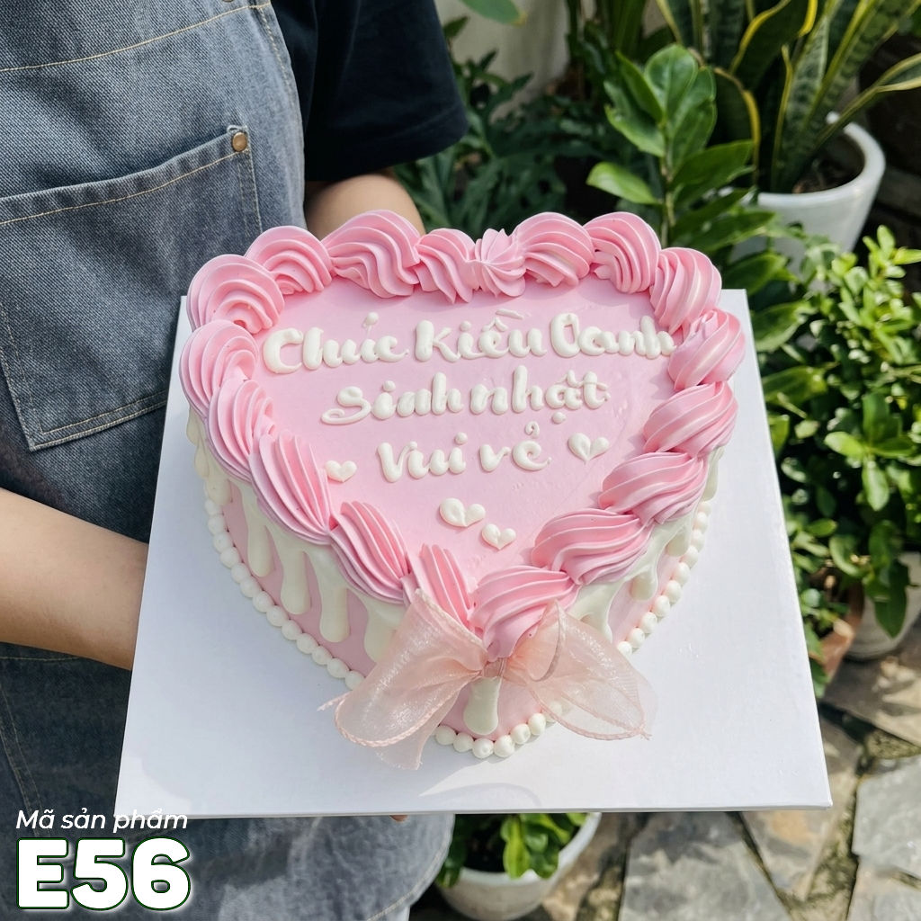 Bánh kem E56 khuôn trái tim màu hồng viền kem và phủ socola trắng quanh thân