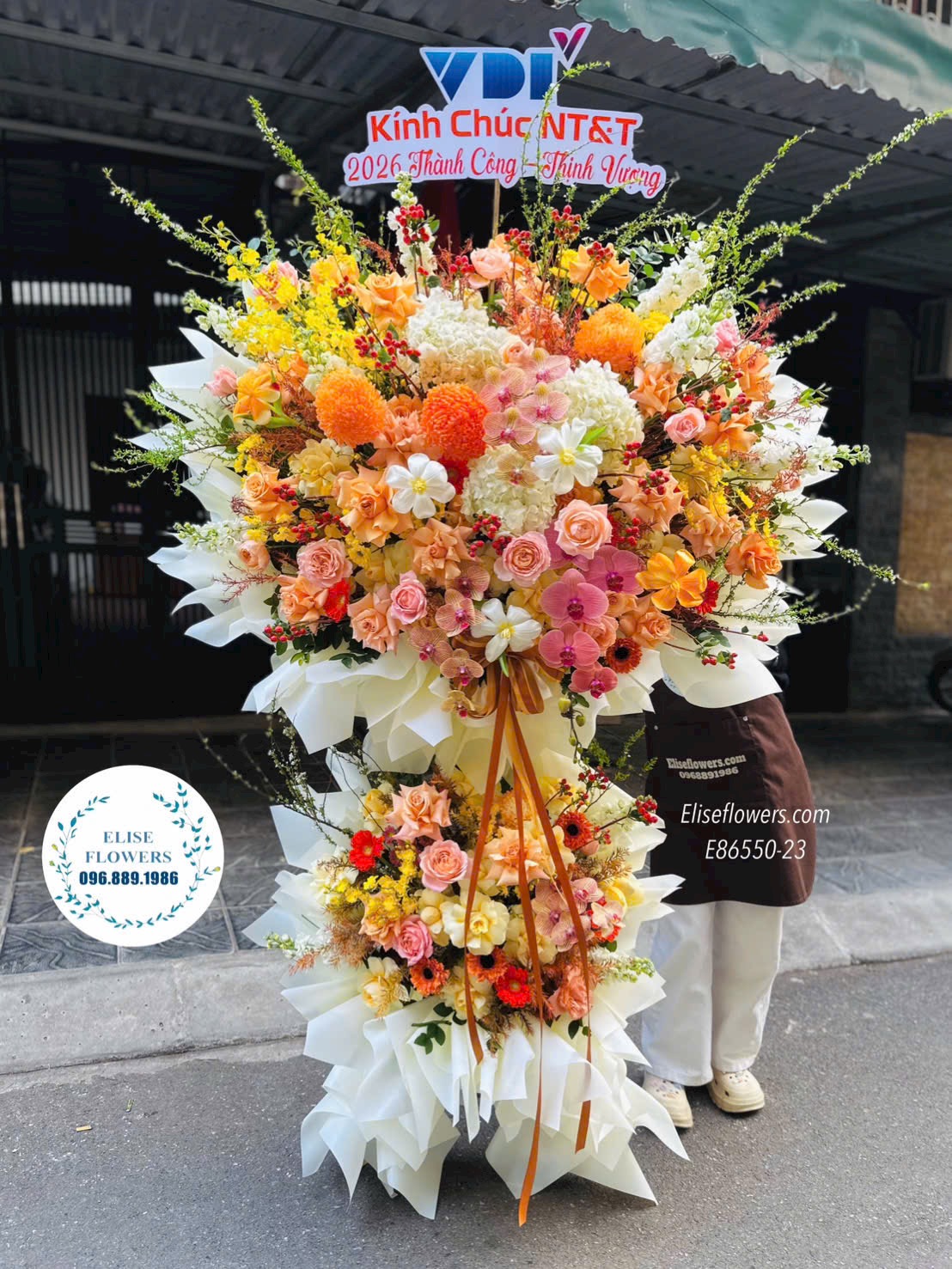 Kệ hoa tone cam vàng chúc mừng kỉ niệm thành lập công ty cỡ lớn. Hoa khai trương Hà Nội