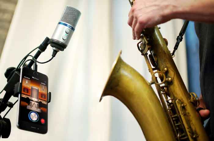Nhạc sĩ đang sử dụng Micro thu âm IK Multimedia iRig Mic Studio để thu âm kèn