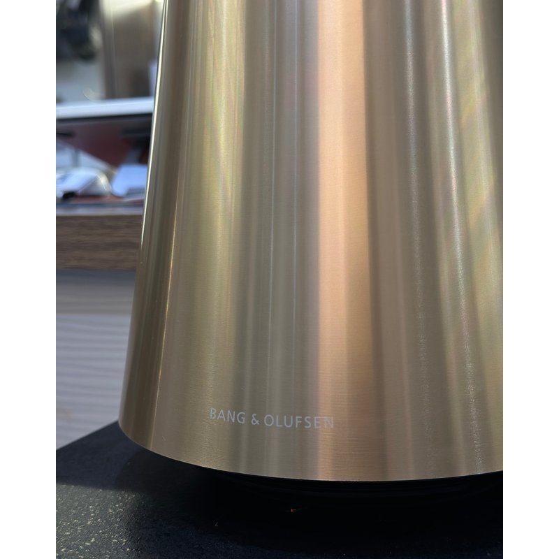 Cận cảnh đế nhôm phay vàng đồng của Beosound 2 Gen 3 với logo Bang & Olufsen