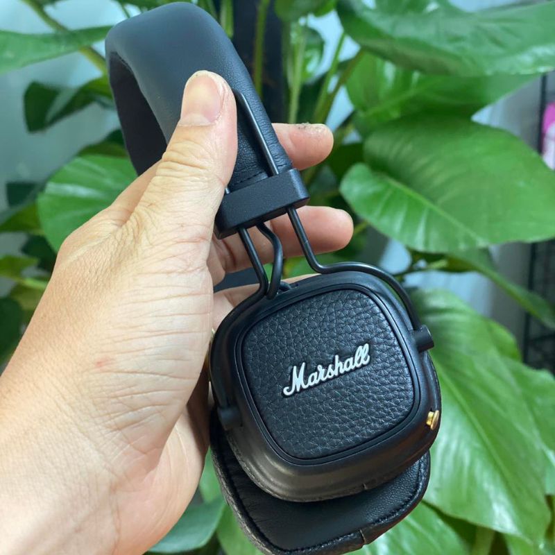 Tai nghe Marshall Major đã bọc giả da đen hoàn thiện — cầm tay, nền xanh lá, nhìn như mới