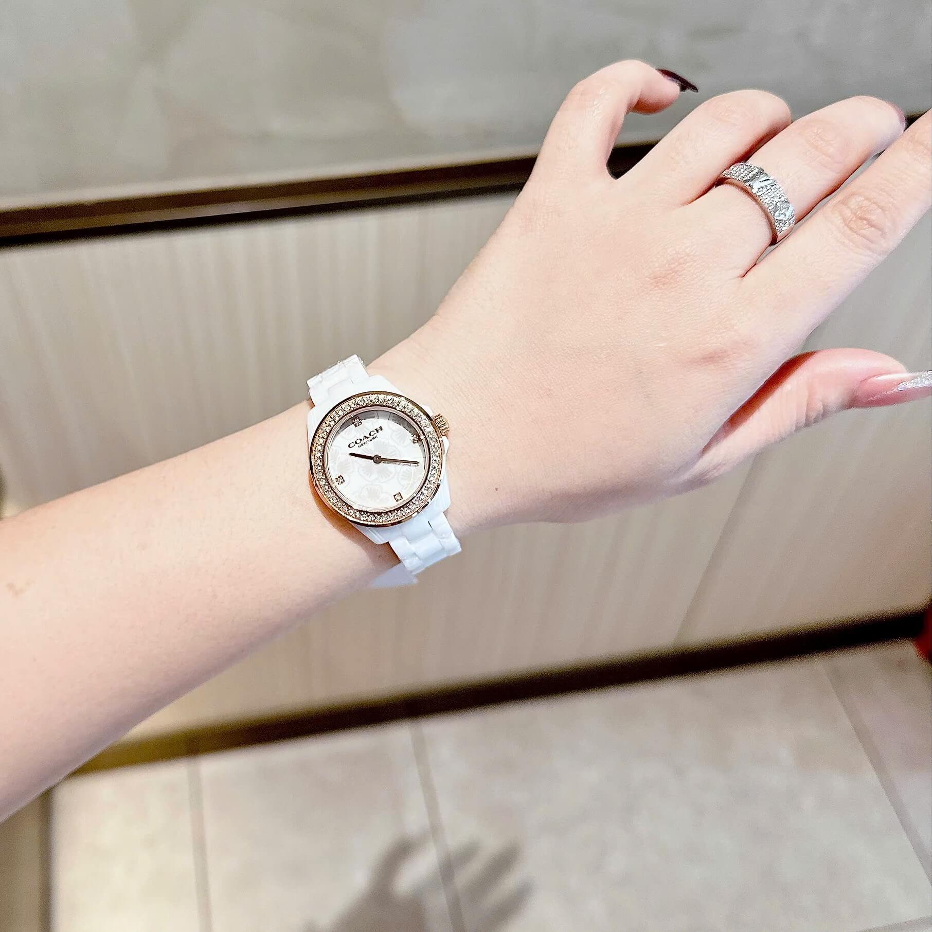 Đồng Hồ Nữ Coach Ceramic Trắng Viền Đá Mặt Họa Tiết Hoa Trà Size 33mm Vỏ Rose Quartz