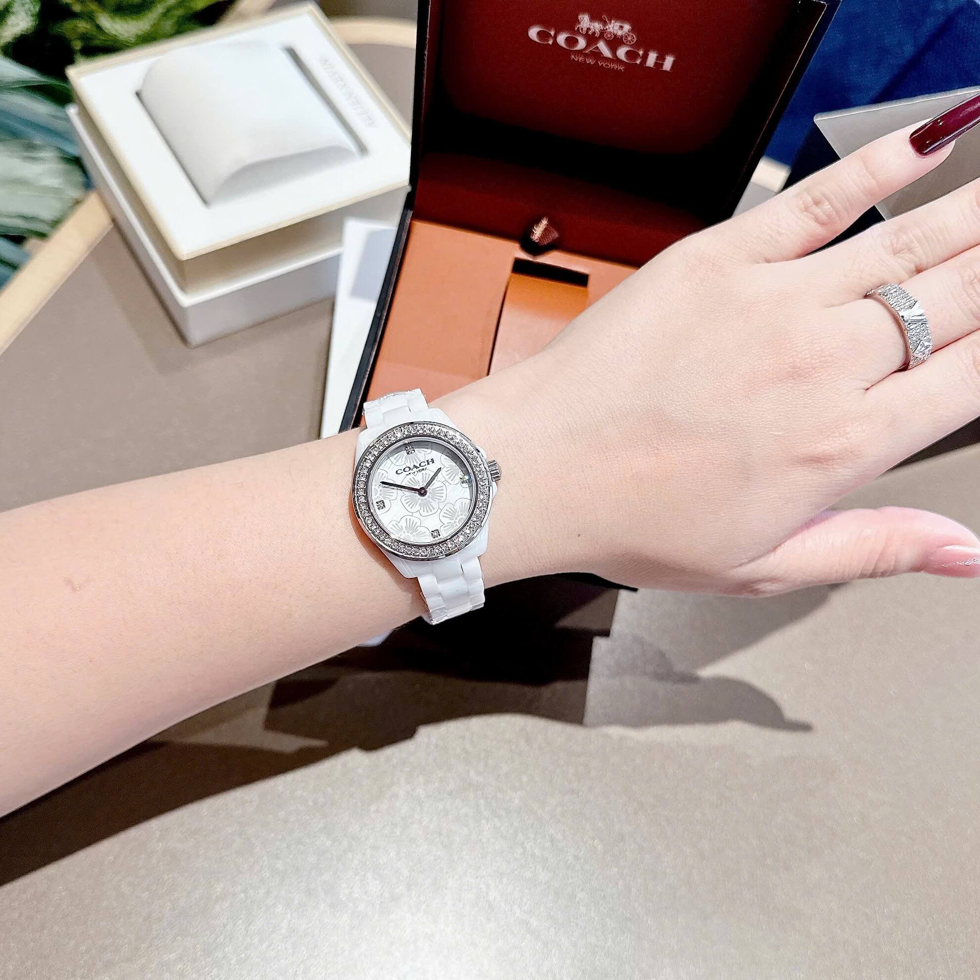 Đồng Hồ Nữ Coach Ceramic Trắng Viền Đá Mặt Họa Tiết Hoa Trà Size 33mm Vỏ Silver Quartz