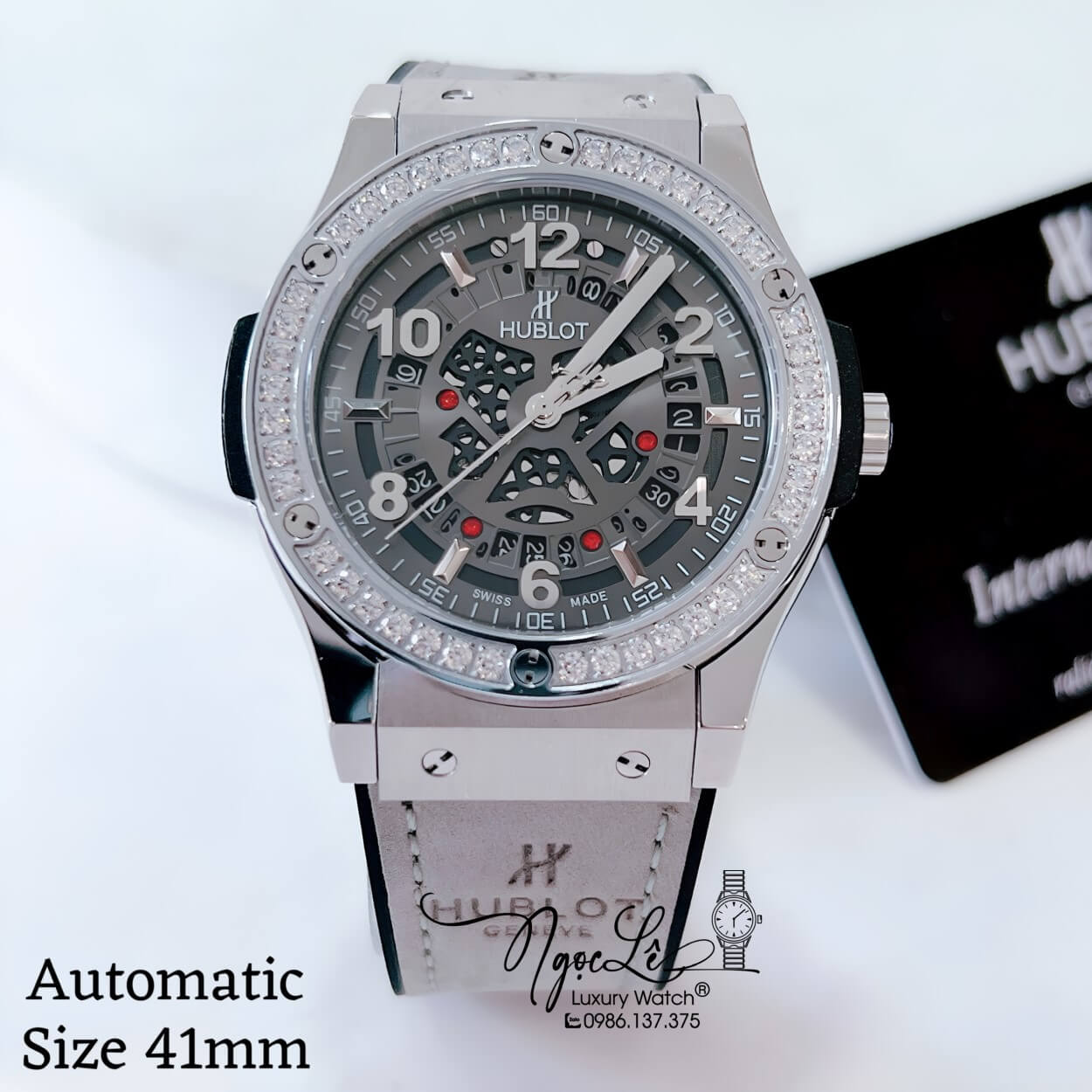 Đồng Hồ Hublot Nam Tự Động Lộ Máy Dây Da Silicon Xám Đính Đá Tròn Vỏ Silver Size 41mm