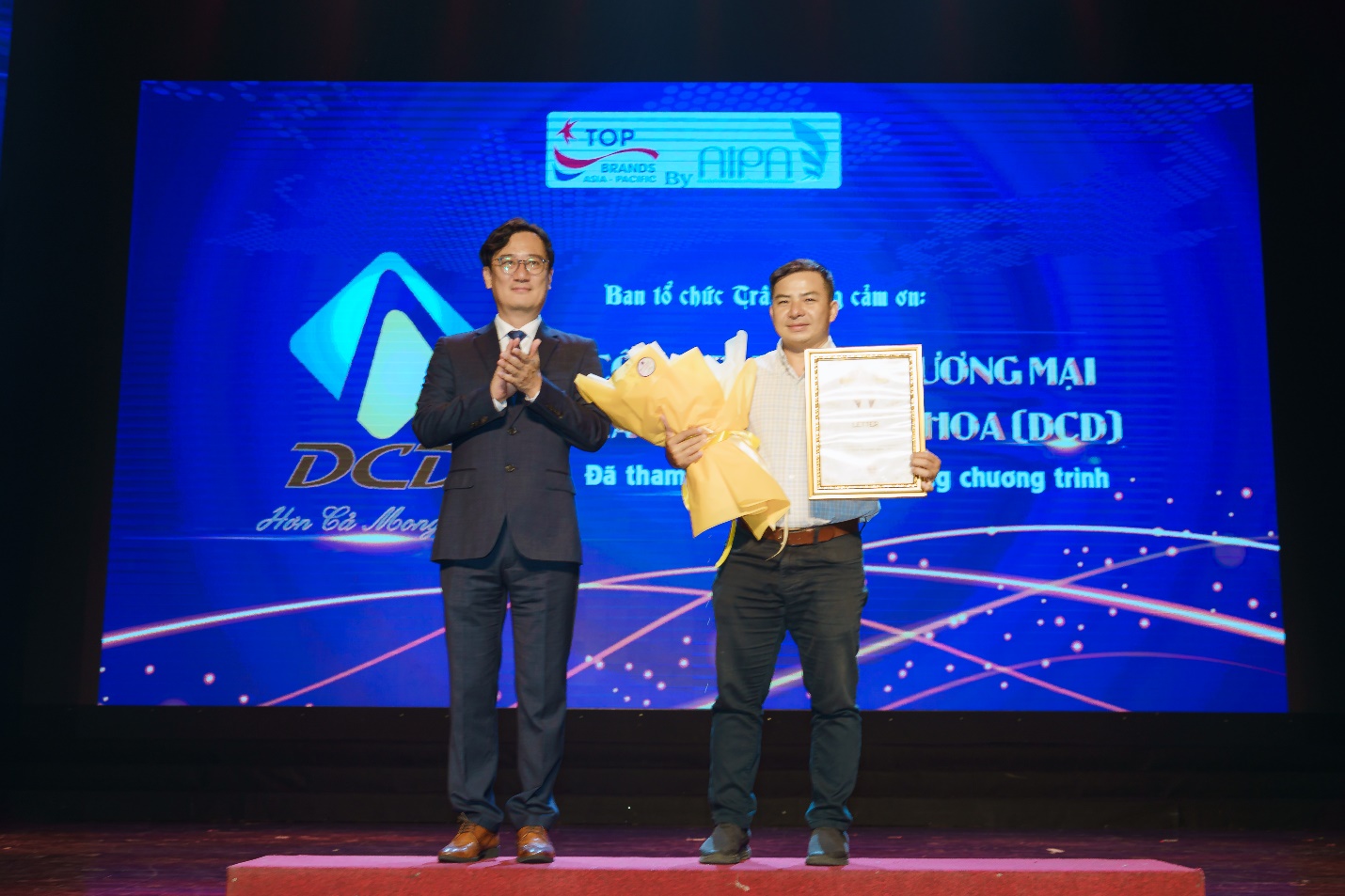 (Ông) Hoàng Huy Cường – Giám đốc kinh doanh đại diện công ty nhận hoa và bằng cảm ơn từ ban tổ chức.