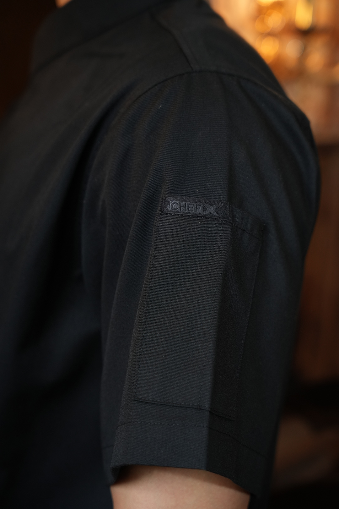 [CHEFX12] ÁO BẾP NGẮN TAY CÚC BẤM MÀU ĐEN CÓ PHỐI LƯỚI CO DÃN SAU LƯNG – BLACK SHORT-SLEEVE CHEF JACKET WITH SNAP BUTTONS AND STRETCH MESH BACK PANEL