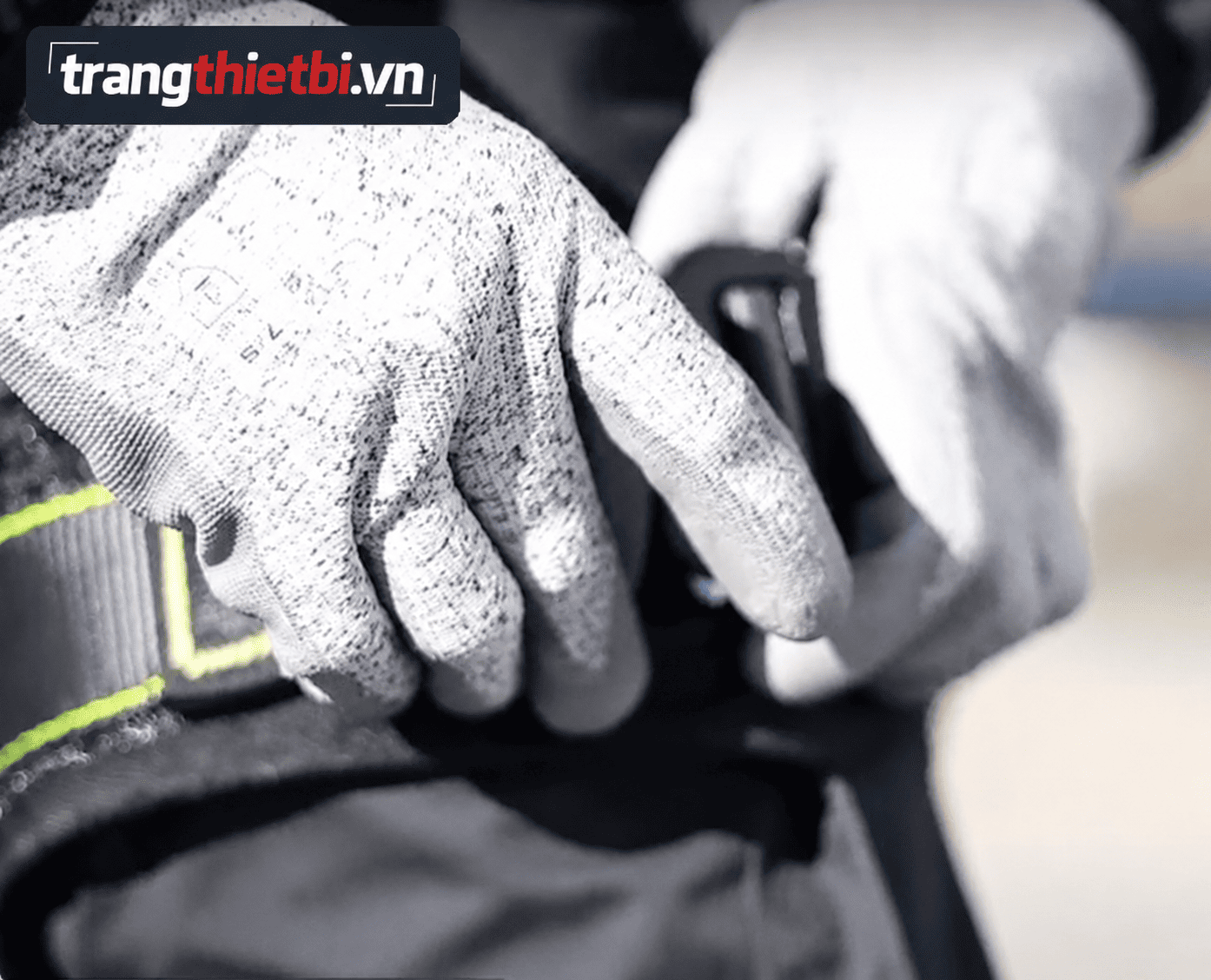 Công nhân đeo găng tay chống cắt thực hiện siết chặt khóa đai bụng của bộ dây an toàn toàn thân