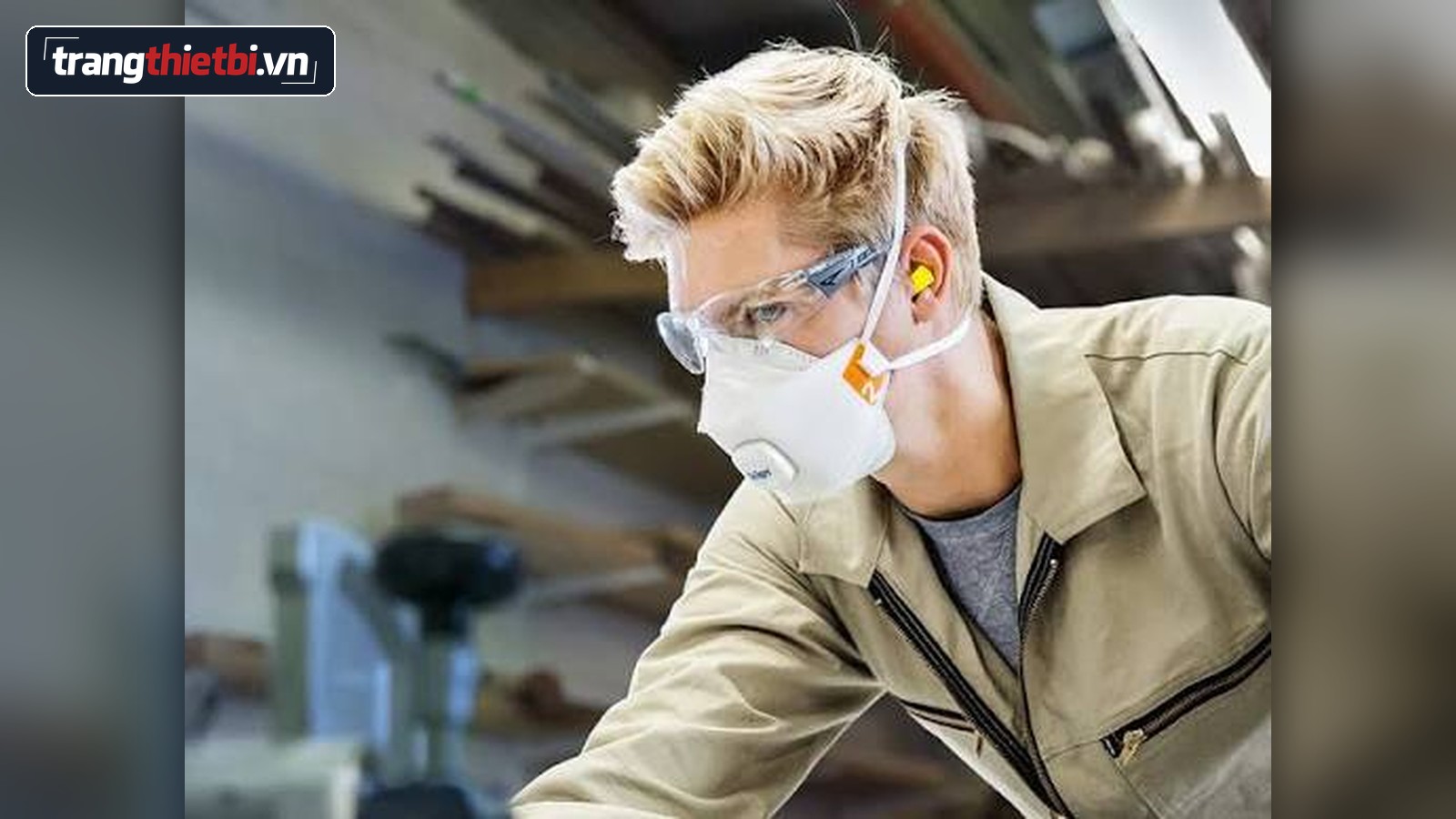 Hình ảnh thực tế công nhân mặc đồ bảo hộ, đeo khẩu trang chống bụi có van thở và kính bảo hộ làm việc an toàn trong xưởng cơ khí