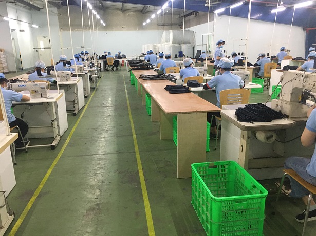 Nhân viên xưởng đang kiểm tra chất lượng balo học sinh đồng phục trước khi bàn giao cho trường học.
