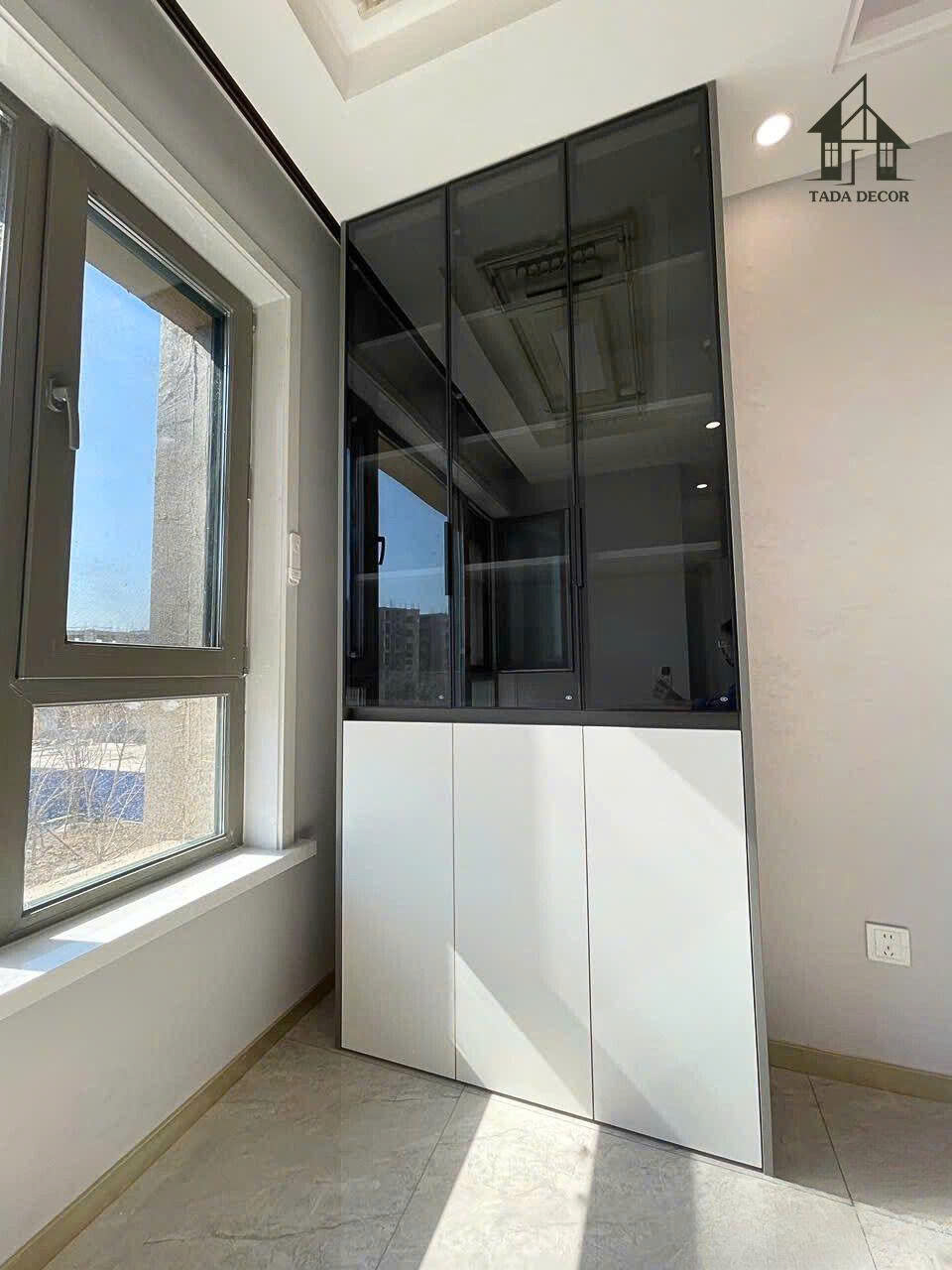 Tủ trưng bày kính đen hiện đại lắp đặt thực tế tại căn hộ Hà Nội – thiết kế sang trọng, tối giản do Tada Việt Nam thi công.