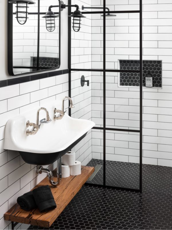 Thiết kế bức tường nhà tắm từ gạch thẻ màu trắng xếp so le trên nền nhà màu đen huyền bí