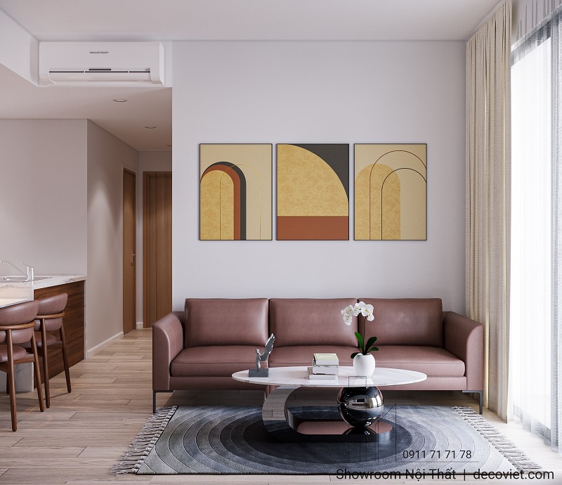 Phòng khách căn hộ với sofa da nâu và tranh treo tường hiện đại