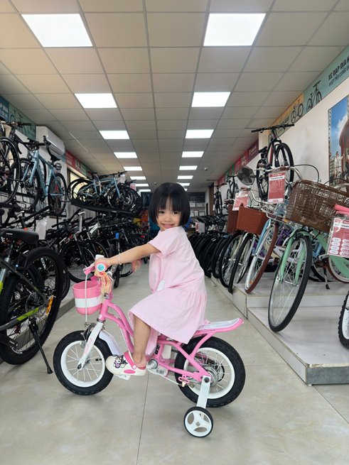 Bé 2-3 tuổi cùng xe đạp tại cửa hàng Bike2School