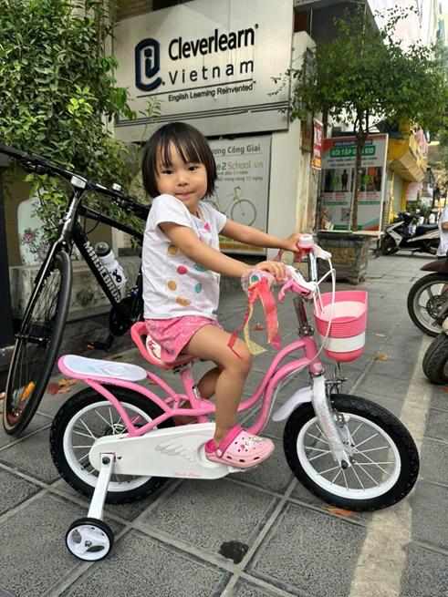 Bé 2-3 tuổi cùng xe đạp tại cửa hàng Bike2School