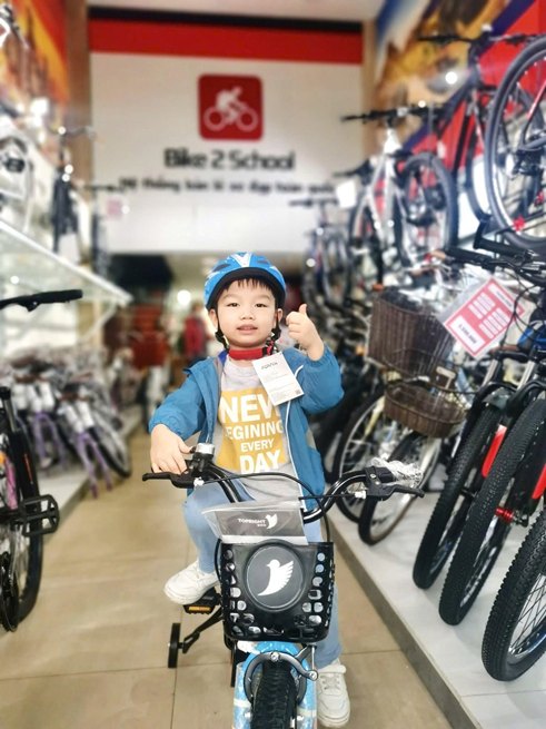 Bé trai cùng xe đạp tại cửa hàng Bike2School