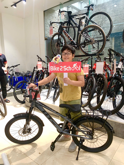 Hai bạn nhỏ cùng xe đạp học sinh tại cửa hàng Bike2School