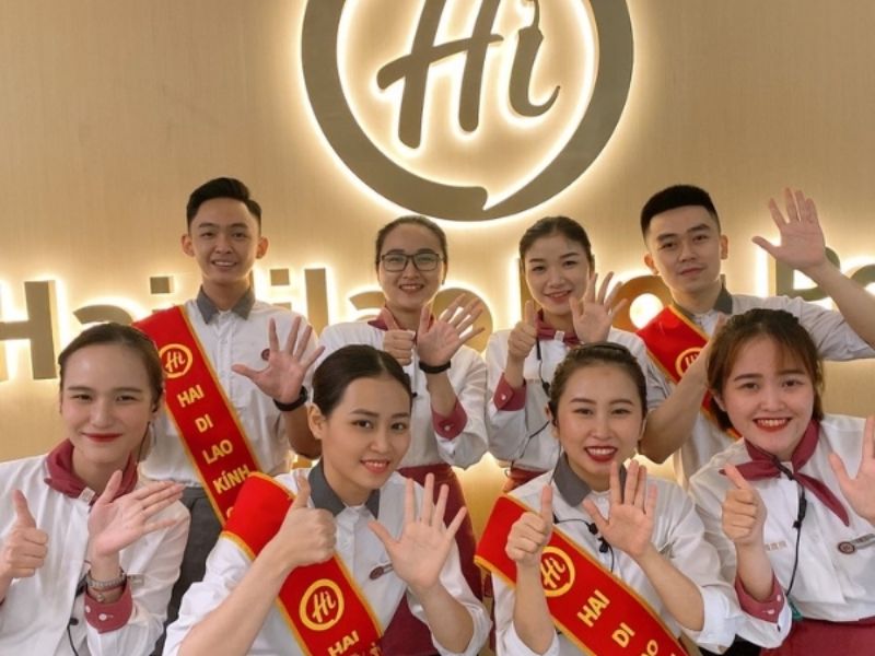 Đồng phục thu ngân Haidilao gồm sơ mi trắng phối đen và quần tối màu, tạo vẻ lịch sự