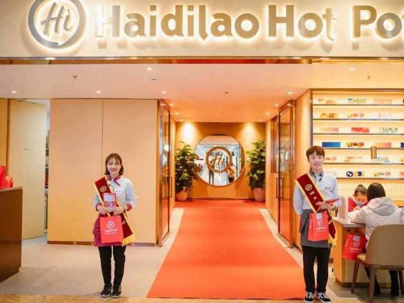 Đồng phục quản lý Haidilao gồm sơ mi trắng, quần tây hoặc chân váy phối vest, tạo vẻ sang trọng
