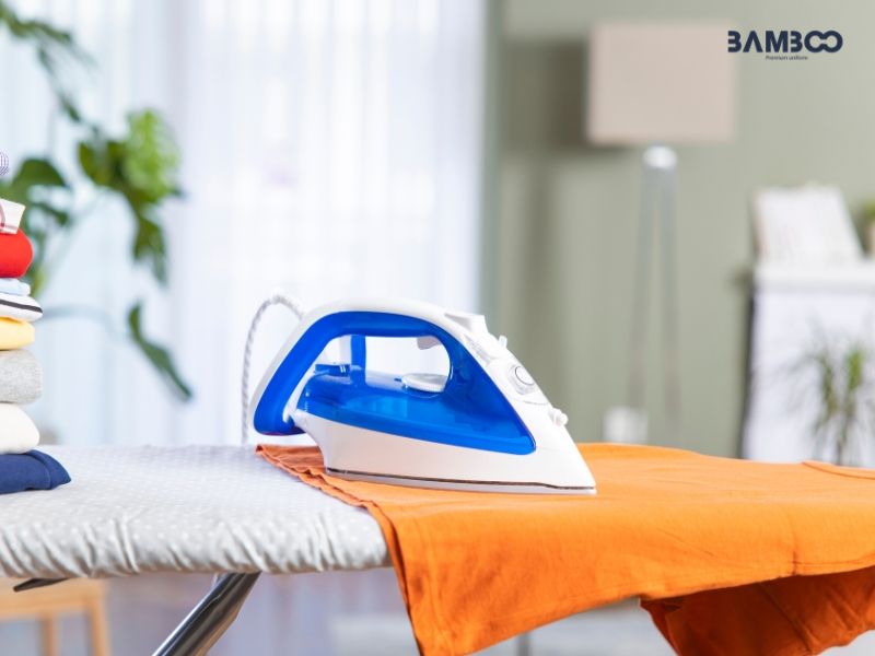 Trải áo lên mặt phẳng và ủi thân áo