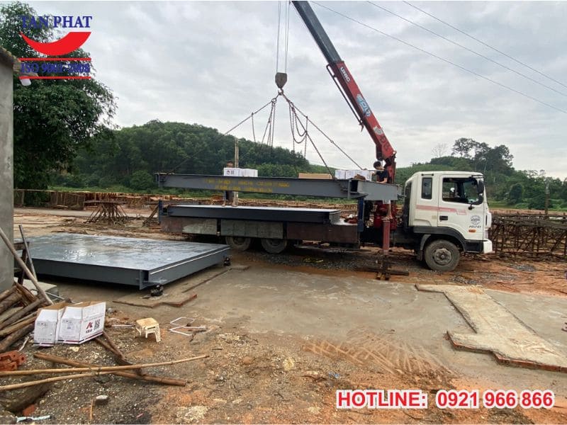 Dùng cẩu đặt để măt bàn cân vào móng cân đã được chuẩn bị sẵn