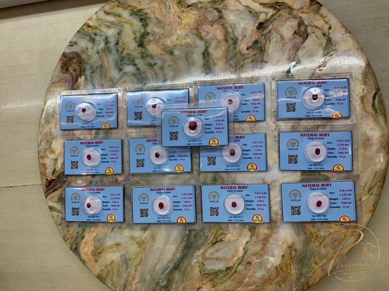 Lô Ruby tự nhiên kiểm định DOJILAB ép vỉ kèm thông số từng viên trên mặt bàn đá