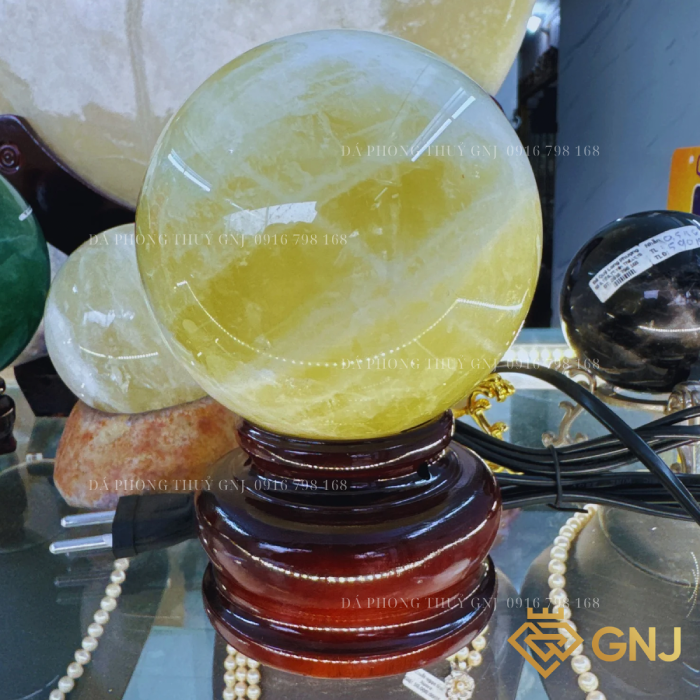 Quả Bi Cầu Đá Thạch Anh Vàng Tự Nhiên — trưng bày trong tủ kính cùng trang sức