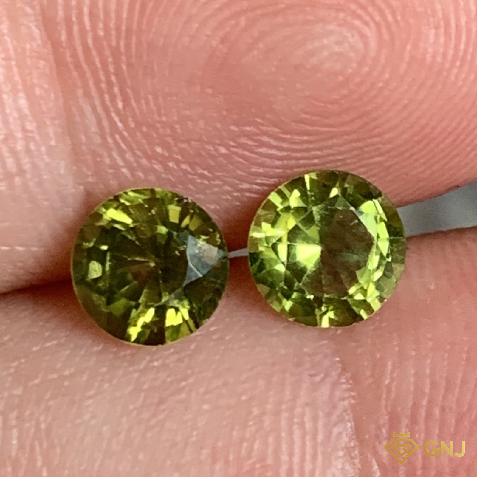 Cặp đá peridot tự nhiên 1,64ct (2 viên) - trên tay