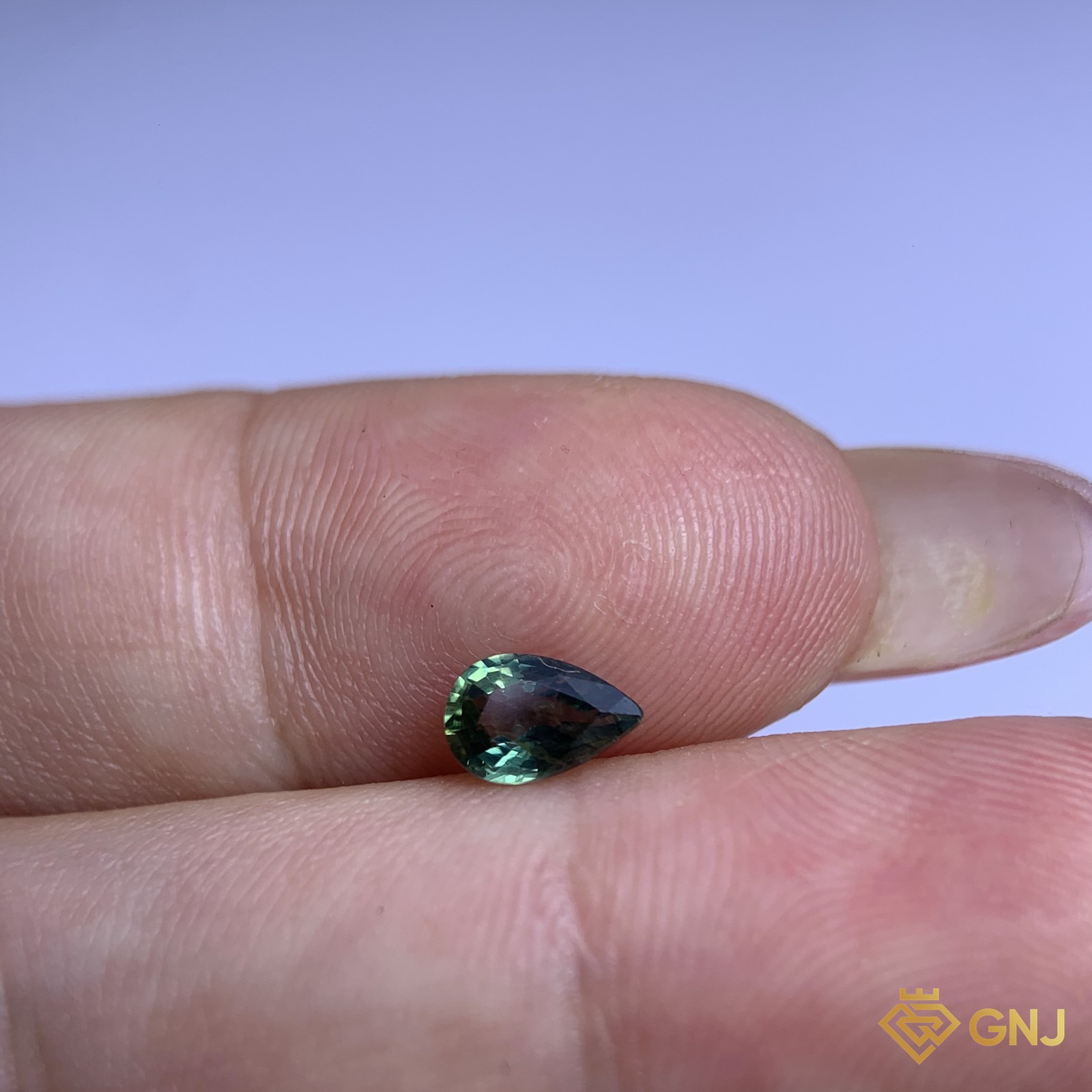 Đá sapphire xanh lá tự nhiên 0,55ct - trên tay